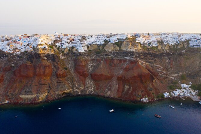 Experience Santorini Sunset by Helicopter - Over Oia: white cliffs, blue domes, and the caldera edge