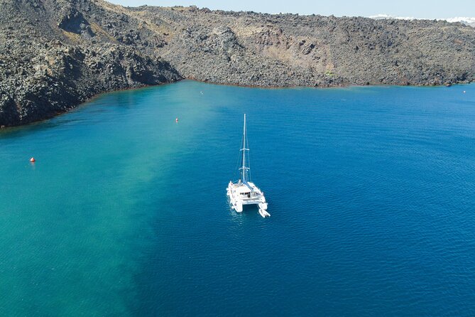 Full Day Santorini Catamaran Private Cruise with meal and transfer - The Faros lighthouse and the Indian head rock photo moment