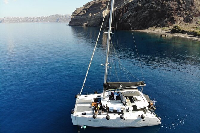 Half-Day Exclusive Catamaran Cruise in Santorini with Meal and Open Bar - Onboard Catamaran Life: Prosecco, Free-Flow Drinks, and the Crew Energy