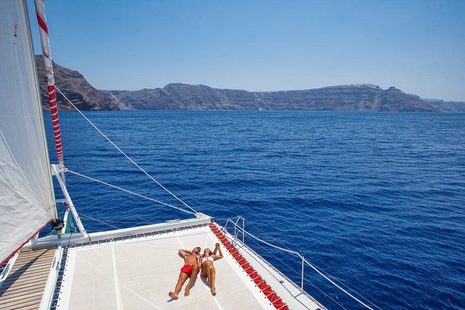 Sailing Catamaran Cruise in Santorini with BBQ, Drinks and Transfer - Hot Springs Stop: Warm Water, Volcano Proximity, and What Time Means