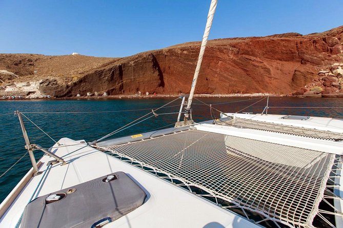 Santorini Half Day Catamaran Private Cruise incl. Meal, Drinks & Free Transport - White Beach and Faros Lighthouse: quieter coves and a time capsule